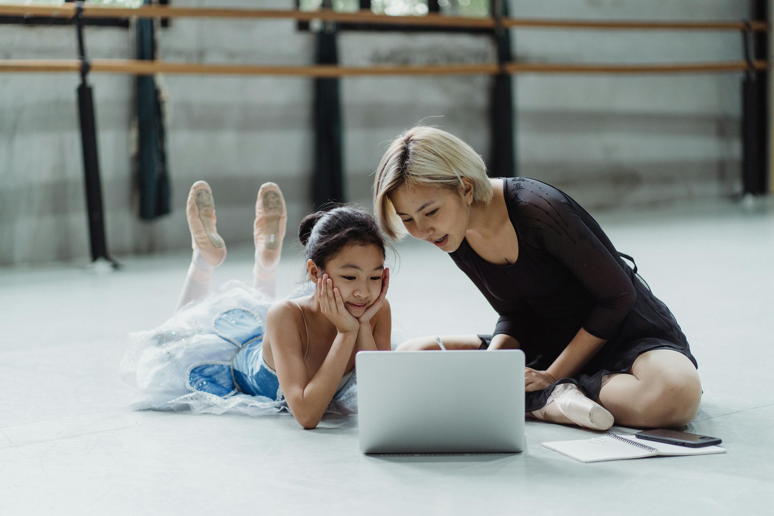 Ballet coach and young student learning online in studio.