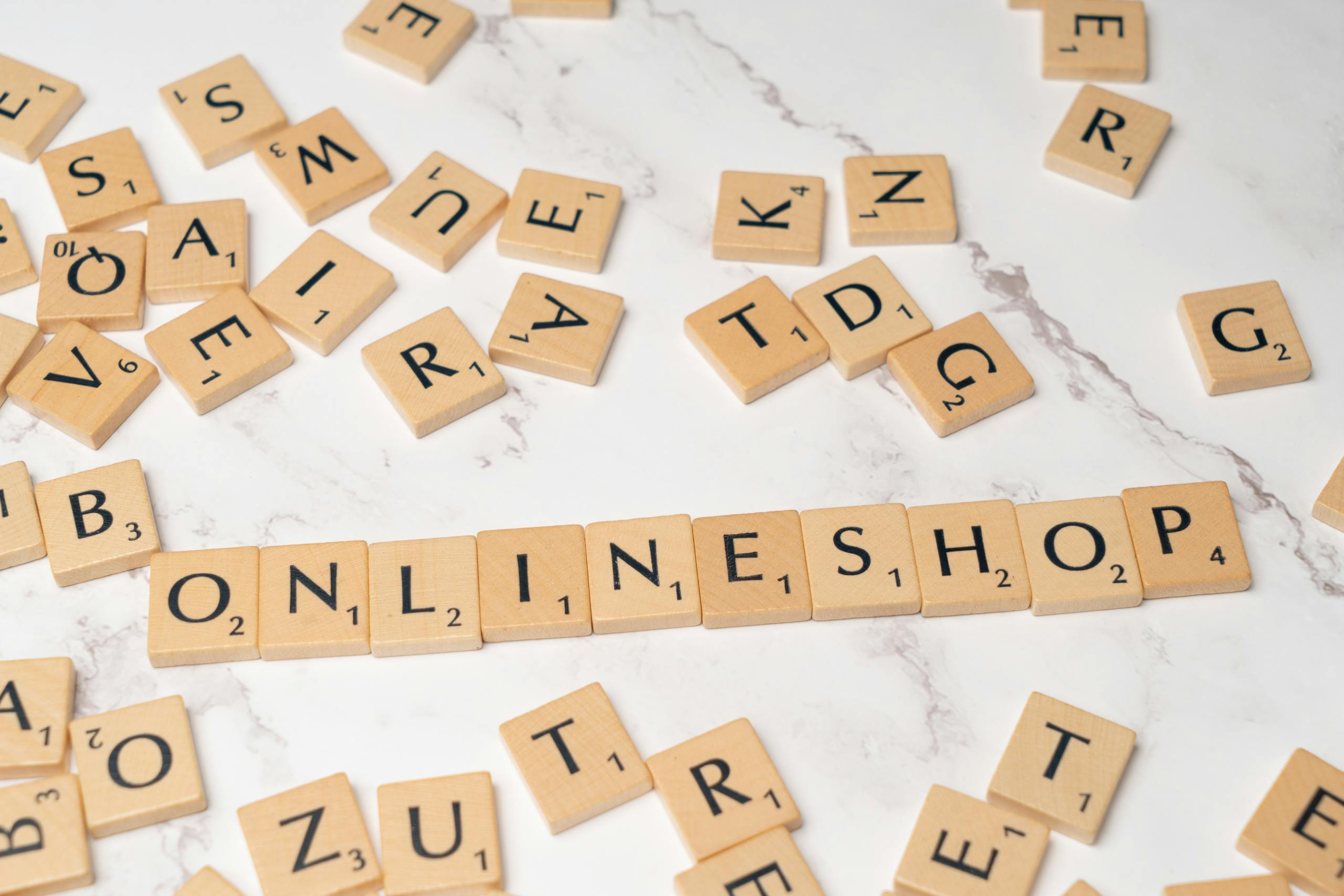 Scrabble tiles arranged to spell 'Online Shop' on marble background for an e-commerce concept.